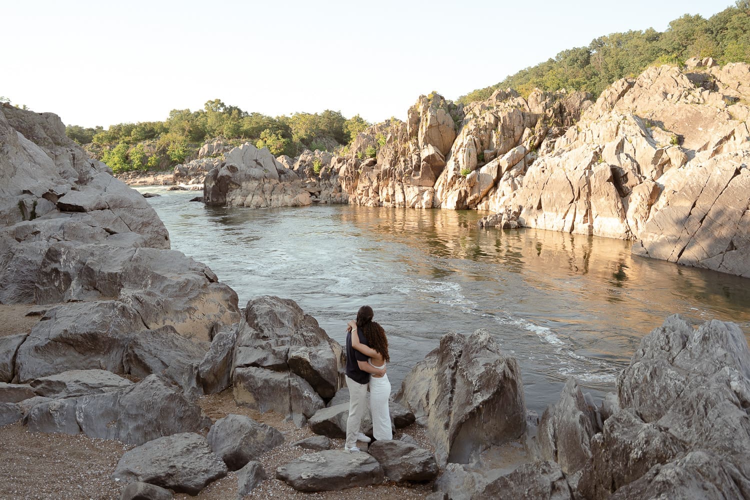 Couple look off and enjoy the views of Great Falls landscape during their sunset elopement.
