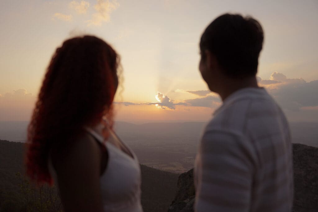 Couple take in the scenic views of their evening elopement as the sun sets behind clouds.
